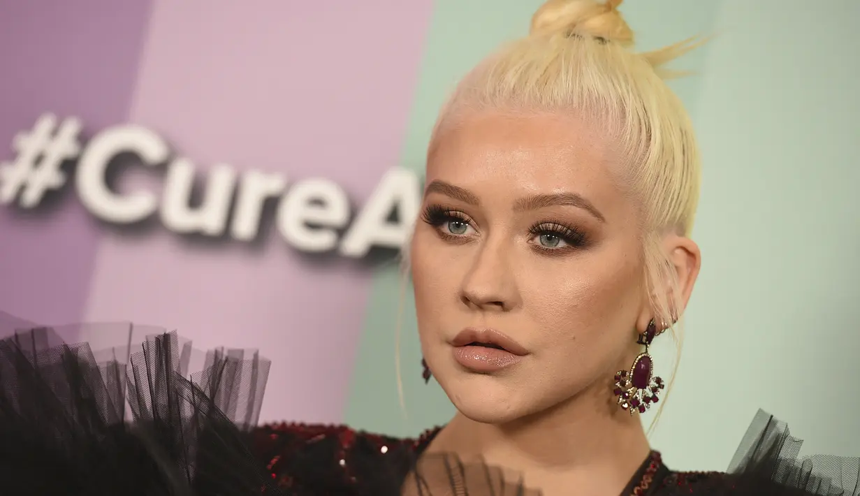 Penyanyi Christina Aguilera berpose saat tiba menghadiri 10th amfAR Gala di Los Angeles, California (11/10/2019). Aguilera tampil anggun dengan gaun hitam serta celana merah berkilau. (AP Photo/Jordan Strauss)