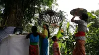 Warga Desa Pakraman Dukuh, Desa Sangkan Gunung, Kecamatan Sidemen, Karangasem memohon air suci atau tirta di sebuah pohon pule yang letaknya bersebelahan dengan Pura Puseh Desa Pakraman Dukuh kemarin. (Dewa Ayu Pitri Arisanti/Radar Bali)