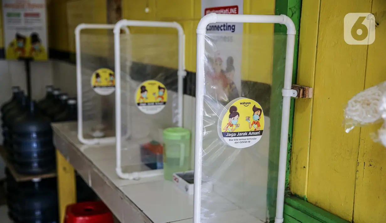 Plastik pembatas terlihat di Warteg Ellya yang menerapkan protokol kesehatan pencegahan penyebaran COVID-19, Cilandak Timur, Pasar Minggu, Jakarta, Selasa (21/7/2020). Pelayan Warteg Ellya diwajibkan menggunakan pelindung wajah dan sarung tangan saat melayani pengunjung. (Liputan6.com/Faizal Fanani)
