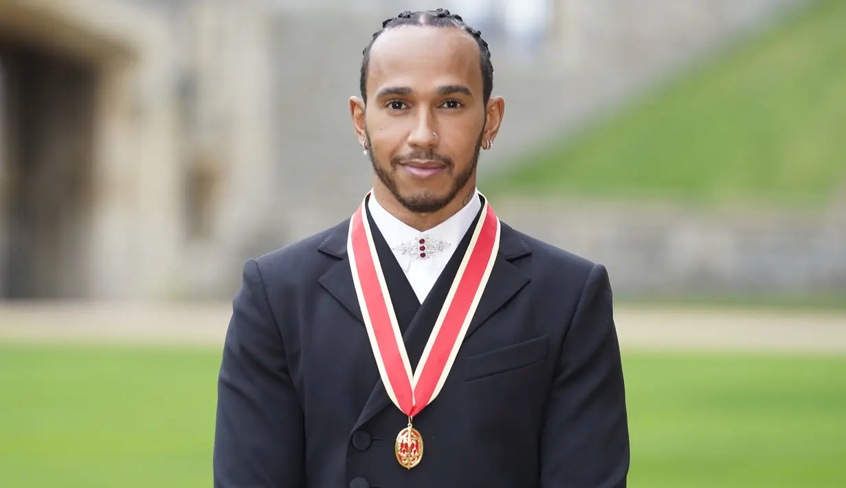 Pembalap Lewis Hamilton berpose seusai penobatannya sebagai Knight Bachelor oleh Pangeran Charles di Kastil Windsor di Windsor, Inggris, Rabu (15/12/2021). Lewis tercatat sebagai pembalap keempat bergelar "Sir" dari Kerajaan Inggris. (Andrew Matthews/Pool Photo via AP)