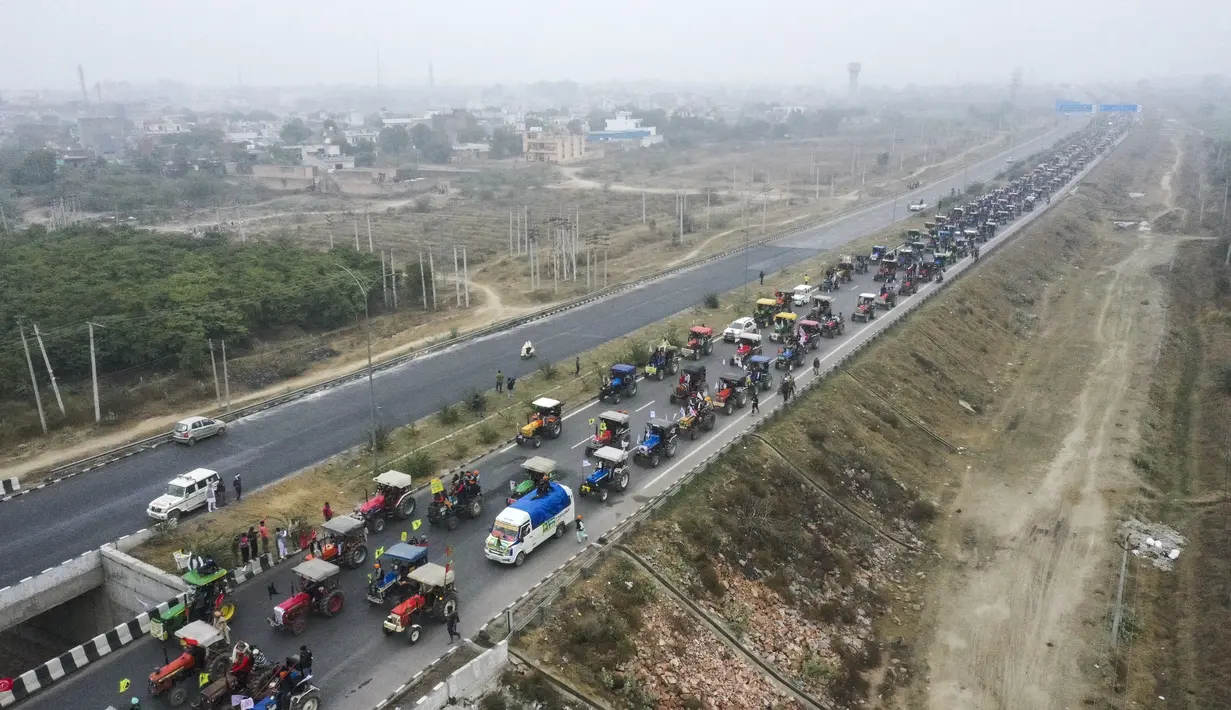 Para petani membawai traktor berpartisipasi dalam unjuk rasa di Jalan Tol Kundli – Manesar – Palwal (KMP) di Kundli di negara bagian Haryana (7/1/2021). Mereka menentang reformasi pertanian pemerintah pusat baru-baru ini. (AFP/Prakash Singh)