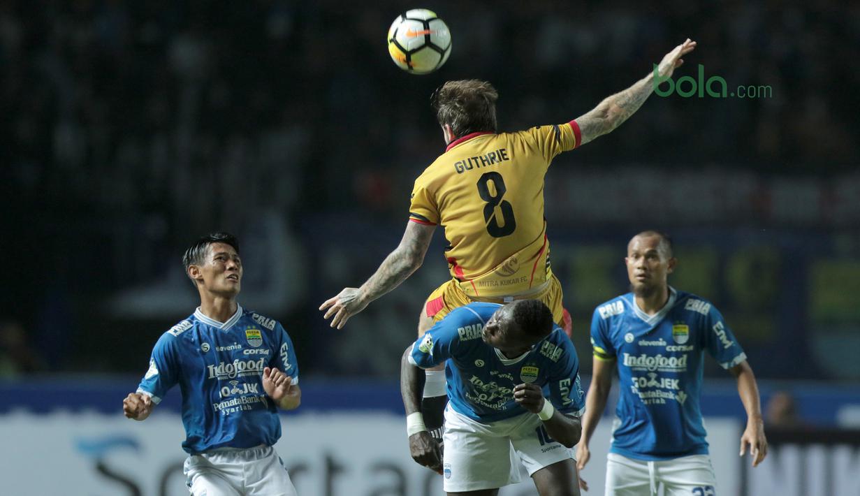 Pemain Persib Bandung, Ezechiel Ndouasel  berebut bola dengan pemain Mitra Kukar, Danny Guthrie pada laga Liga 1 Indonesia di GBLA, (8/4/2018). Persib Bandung menang 2-0. (Bola.com/Nick Hanoatubun)