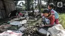 Pekerja perempuan membawa anak saat bekerja mengupas buah aren di Kampung Citugu, Desa Puraseda, Leuwiliang, Kabupaten Bogor, Jawa Barat, Minggu (25/4/2021). Dalam sehari, satu petani di kampung ini mampu menghasilkan 80-100 kg kolang-kaling. (merdeka.com/Iqbal S. Nugroho)