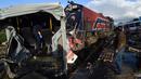 Tim penyelamat memeriksa kondisi bus yang dihantam kereta di rel dekat wilayah Sidi Fathallah, sekitar 10 km selatan Ibu Kota Tunisia, Rabu (28/12). Bus itu terbelah dua ketika dihantam kereta dan menyebabkan lima orang tewas. (Fethi Belaid/AFP)