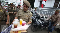 Petugas membawa minuman millik PKL di kawasan wisata Kota Tua, Jakarta, Rabu (24/8). Penertiban dilakukan guna membenahi PKL dan parkir liar yang kerap menimbulkan kesemrawutan di lokasi tersebut. (Liputan6.com/Immanuel Antonius)