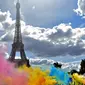 Bermacam serbuk warna bertebaran saat acara Color Run 2017 di depan Menara Eiffel, Paris, Minggu (16/4). Lomba lari sepanjang 5 km tanpa hadiah itu diikuti ribuan peserta. (AFP PHOTO / CHRISTOPHE ARCHAMBAULT)