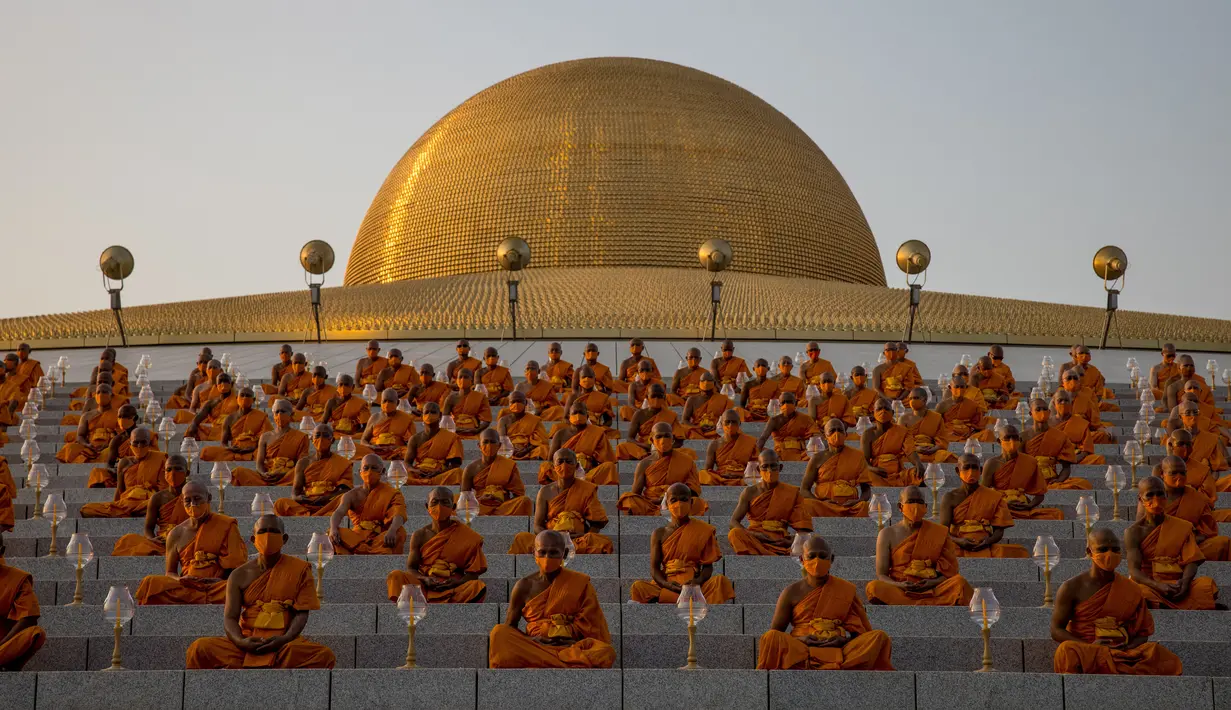 Biksu Buddha menghadiri perayaan Makha Bucha di tengah pandemi COVID-19, di Wat Dhammakaya, Bangkok, Jumat (26/2/2021). Perayaan Makha Bucha merupakan upacara keagaamaan terbesar di Thailand. Pada perayaan itu, warga Buddha bersembahyang dan memberikan sedekah kepada para biksu. (Jack TAYLOR/AFP)