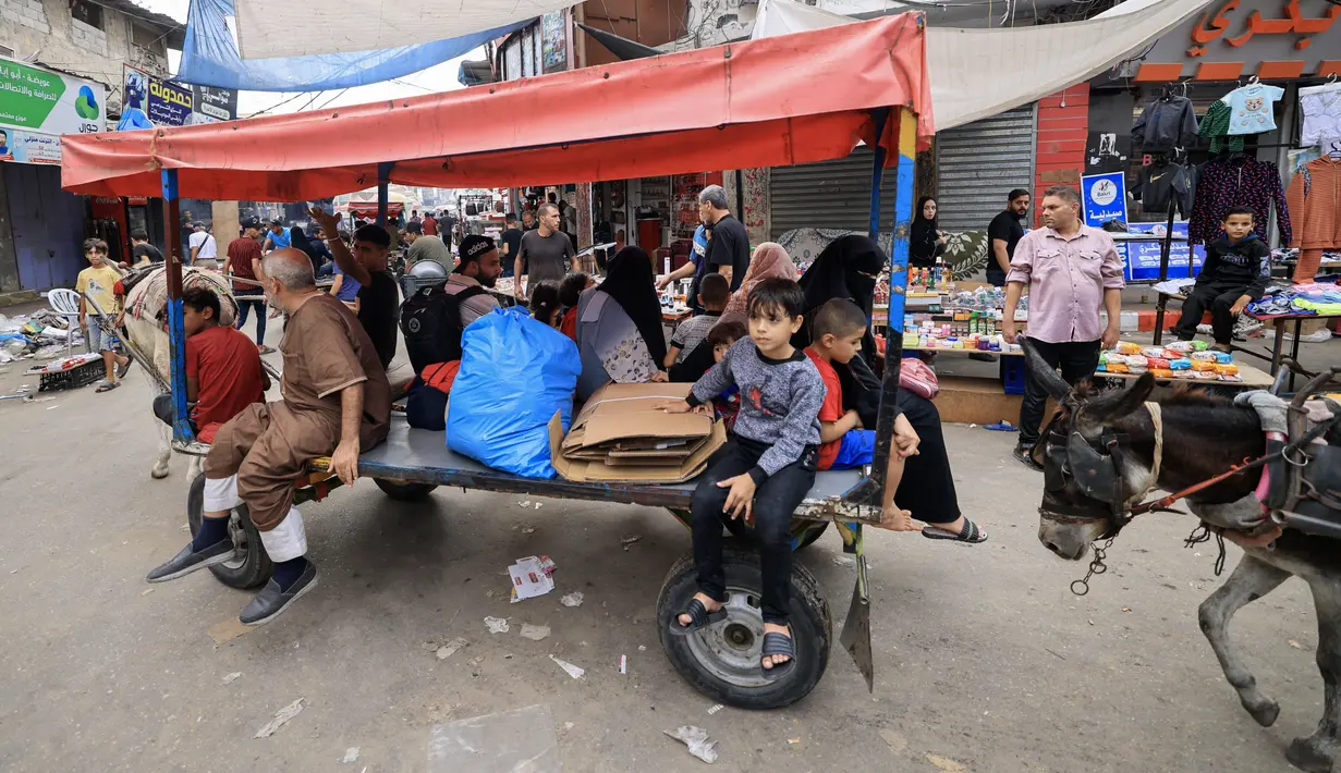 <p>Warga Palestina menggunakan gerobak yang ditarik keledai untuk transportasi di Khan Yunis di Jalur Gaza selatan, karena kekurangan bahan bakar mobil di tengah pertempuran yang sedang berlangsung antara Israel dan Hamas, 28 Oktober 2023. (Mahmud HAMS / AFP)</p>