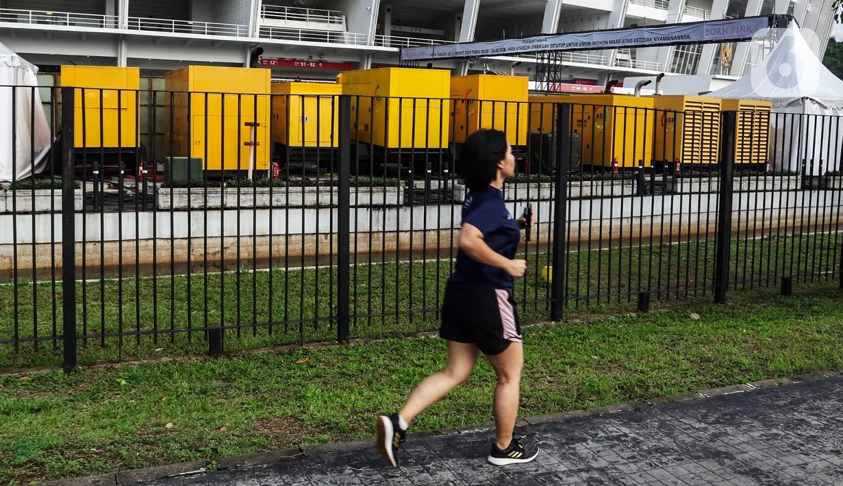 Seorang wanita berolahraga di luar area Stadion Utama Gelora Bung Karno (SUGBK), Jakarta, Jumat (10/3/2023). Jelang konser girl band asal Korea Selatan, Blackpink, SUGBK ditutup sementara untuk umum dari tanggal 10-12 Maret 2023. (Liputan6.com/Johan Tallo)