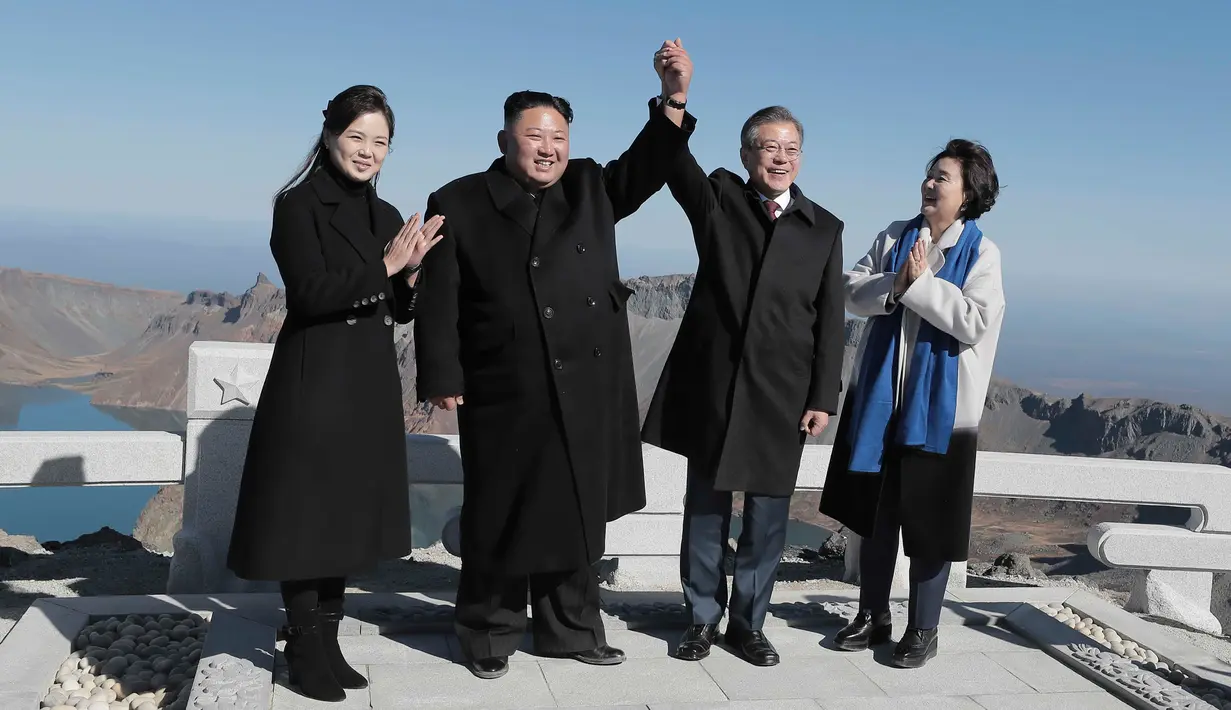 Presiden Korea Selatan Moon Jae-in (dua kanan) dan sang istri Kim Jung-sook (kanan) foto bersama Pemimpin Korea Utara Kim Jong-un (dua kiri) dan sang istri Ri Sol Ju (kiri) di Gunung Paektu, Korea Utara, Kamis (20/9). (Pyongyang Press Corps Pool via AP)