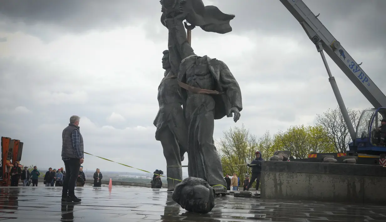 <p>Sebuah monumen era Soviet untuk persahabatan antara Rusia dan Ukraina terlihat selama pembongkarannya, di tengah invasi Moskow di Kiev tengah, Ukraina, Selasa (26/4/2022). Patung perunggu setinggi 8 meter itu menggambarkan seorang pekerja Ukraina dan Rusia di atas alas, memegang tinggi-tinggi tatanan persahabatan Soviet. (Genya SAVILOV / AFP)</p>