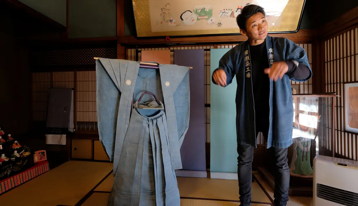 Seorang pengrajin bernama Yuichi Hirose memperkenalkan sebuah kimono tua yang dipakai oleh samurai selama periode Edo di Tokyo, Jepang (1/3). Gaya dari pemakaian kimono biasanya merepresentasikan status sosial seseorang. (AFP/Kazuhiro Nogi)