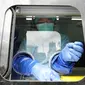 Seorang petugas kesehatan bersiap untuk mengambil sampel usap hidung saat pengujian publik untuk virus corona COVID-19 baru yang dilakukan di stasiun kereta api di Bekasi, Jawa Barat, Rabu (2/2/2022). (AP Photo/Achmad Ibrahim)