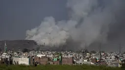 Asap mengepul dari TPA Ghazipur yang sebagian terbakar di pinggiran New Delhi, India (28/3/2022). Kebakaran besar terjadi di tempat pembuangan sampah di daerah Ghazipur Delhi timur yang menyebabkan kepulan asap besar menyelimuti wilayah tersebut dan daerah tetangga. (AP Photo/Altaf Qadri)
