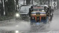 Bajaj saat menerobos hujan di Jalan Pramuka, Jakarta, Kamis (18/2/2021). Badan Meteorologi Klimatologi dan Geofisika (BMKG) mengimbau pengguna jalan agar berhati-hati saat berkendara karena hujan disertai angin kencang diprediksi terus berlanjut hingga akhir Februari. (merdeka.com/Iqbal S Nugroho)
