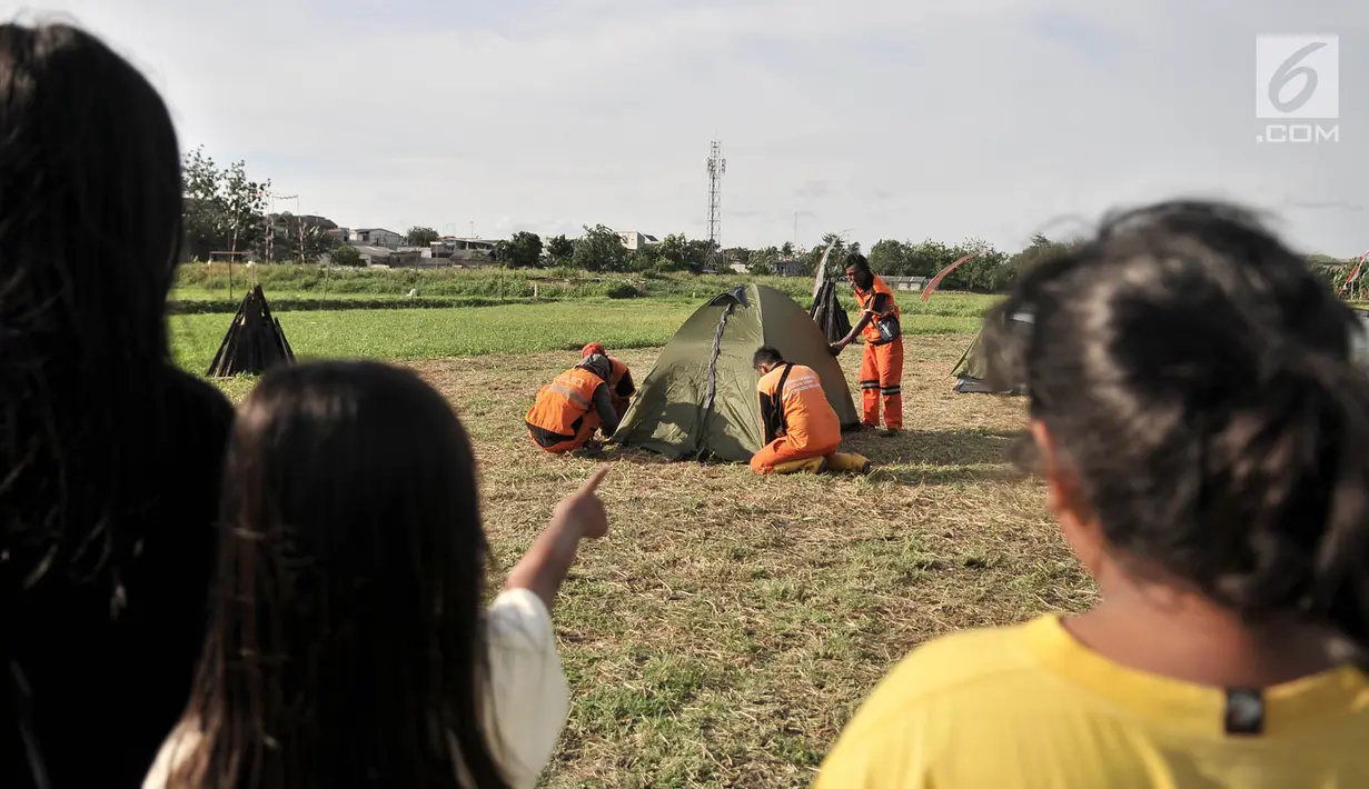 Warga menyaksikan petugas PPSU mendirikan tenda saat persiapan untuk doa bersama pada malam Tahun Baru di Cipinang Melayu, Jakarta, Minggu (30/12). (Merdeka.com/ Iqbal S. Nugroho)