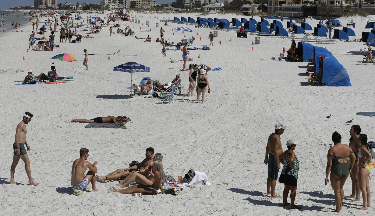 Pengunjung menikmati Clearwater Beach di Florida, Amerika Serikat, Rabu (18/3/2020). Virus corona COVID-19 sudah menyebar ke seluruh wilayah Amerika Serikat dengan jumlah kasus sebanyak 5.359 dan menewaskan 100 orang. (AP Photo/Chris O'Meara)