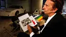 Tragedi San Marino Grand Prix 1994 di Italia menewaskan pembalap asal Brasil, Ayrton Senna. Mantan pembalap F1 Brasil Emerson Fittipaldi memegang gambar Ayrton Senna, Sao Paolo, Kamis (10/04/2014) (Reuters/Paulo Whitaker).