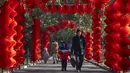 <p>Seorang pria dan anak laki-laki berjalan di sepanjang jalan yang dihiasi lentera untuk Tahun Baru Imlek mendatang di sebuah taman umum di Beijing, Jumat, 20 Januari 2023. Tahun Kelinci secara resmi dimulai pada 22 Januari. (AP Photo/Mark Schiefelbein)</p>