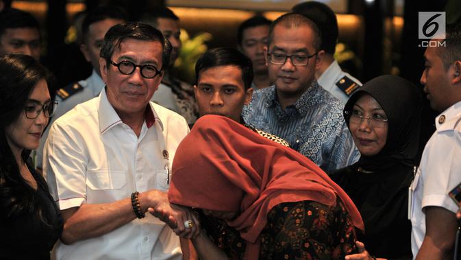 Terpidana kasus pelanggaran ITE Baiq Nuril mencium tangan Menkumham Yasonna Laoly usai menggelar pertemuan di Kantor Menkumham, Jakarta, Senin (8/7/2019). Baiq Nuril menegaskan tak akan menyerah berjuang memenangkan kasusnya. (merdeka.com/Iqbal Nugroho)