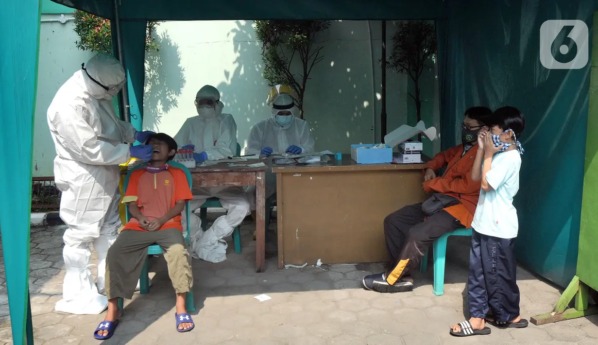 Paramedis melakukan kegiatan testing PCR kepada warga yang pernah berhubungan dengan pasien positif COVID-19 di Puskesmas Cinere, Depok, Jawa Barat, Kamis (10/6/2021). Testing setelah tracing dilakukan kepada puluhan warga untuk meminimalisir penyebaran COVID-19. (merdeka.com/Arie Basuki)