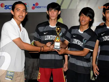 Ketua Panitia dari Universita Gunadarma memberikan tropi kepada salah satu pemenang lomba futsal (Liputan6.com/Andrian Martinus)