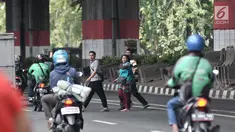 Pejalan kaki menyeberangi jalan di JPO di Prumpung, Jakarta, Selasa (18/9). Minimnya kesadaran warga menyeberangi jalan tanpa menggunakan JPO dapat membahayakan keselamatan serta menyebabkan kecelakaan.(merdeka.com/ Iqbal S. Nugroho)