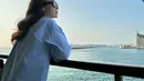 Pamela Bowie terlihat sedang memandang laut yang begitu indah. Penampilannya kala itu terlihat cantik dengan kemeja denim yang dipadukan dengan celana jeans serta kaca mata hitam