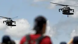 Sejumlah warga menyaksikan aksi manuver helikopter Blackhawk-Arpia di F-Air Colombia 2015 di F-Air Colombia 2015 di Rionegro, Kolombia (9/7/2015). Heli ini sering digunakan untuk misi-misi pasukan khusus. (REUTERS/Fredy Builes)