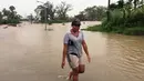 Seorang wanita berjalan melewati genangan banjir yang melanda Ba, wilayah barat Fiji, Rabu (6/4). Otoritas Fiji memerintahkan warganya untuk tetap berada di dalam ruangan seiring semakin mendekatnya siklon Tropis Zena. (NAZIAH ALI/MAI LIFE MAGAZINE /AFP)