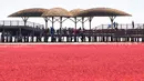 Orang-orang mengunjungi Pantai Merah di Panjin, provinsi Liaoning timur laut China (27/8/2021). Ada sekitar 100 varietas seepweed yang tumbuh di lahan basah pasang surut di dunia. Tetapi tanaman Suaeda yang tumbuh di Panjin merupakan spesies yang unik. (AFP/STR)