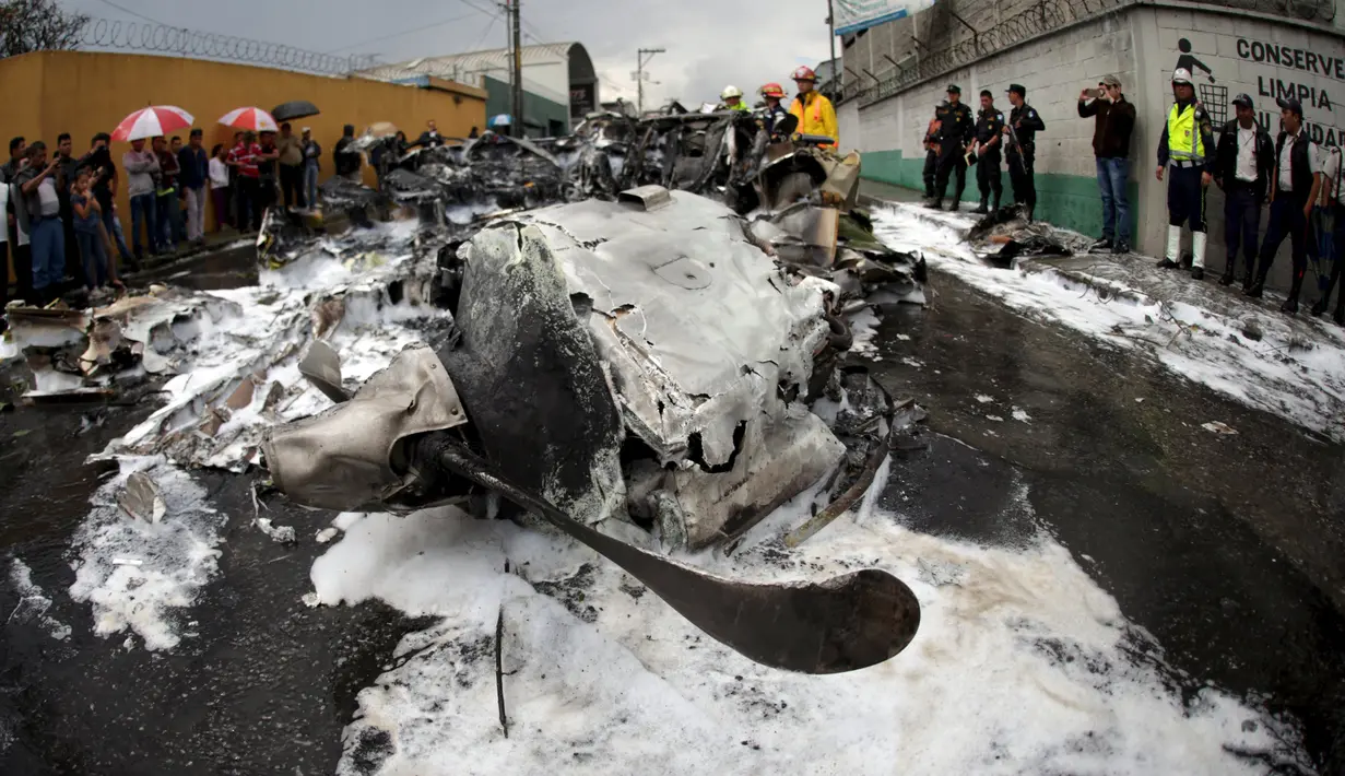 Petugas Polisi berjaga disamping bangkai pesawat yang hangus terbakar di Guatemala City, Guatemala, Sabtu (21/11/2015). Pesawat terjatuh setelah lepas landas dari Bandara Internasional La Aurora. (REUTERS/Jorge Dan Lopez)