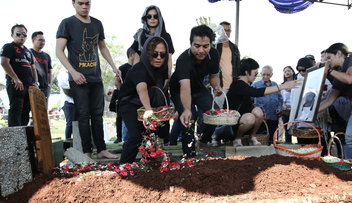 Musisi Indra Lesmana bersama Mira Lesmana menaburkan bunga di pemakamanya ibunya, Nien Lesmana di TPU Tanah Kusir, Jakarta, Rabu (28/6). (Liputan6.com/Herman Zakharia)