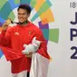 Pesilat Indonesia, Komang Harik Adi Putra menunjukkan medali emas usai memenangkan final Kelas E Putra Asian Games 2018, Jakarta, Senin (27/8). Komang menyumbang emas ke-17 Indonesia di Asian Games 2018. (Merdeka.com/Arie Basuki)