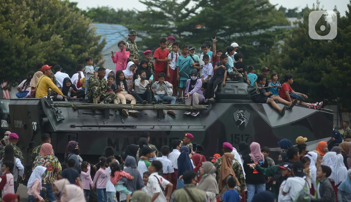 Warga naik tank berkeliling  di lapangan Marinir Cilandak, Jakarta, Selasa (15/11/2022). Kegiatan ini dilakukan dalam rangka peringatan HUT Ke-77 Korps Marinir dibuka untuk warga mencoba berkeliling markas Marinir. (merdeka.com/Imam Buhori)