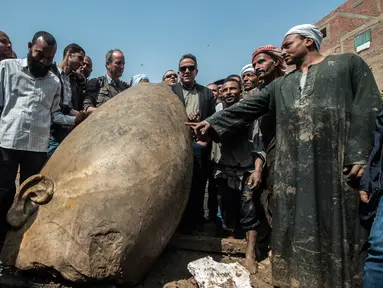 Warga melihat dekat pecahan patung yang ditemukan oleh tim arkeolog Jerman-Mesir di distrik Mattarya, Kairo, Kamis (9/3). Diduga pecahan patung yang digali di sekitar Kuil Ramses II tersebut berasal dari dinasti XIX (1295-1185 SM)