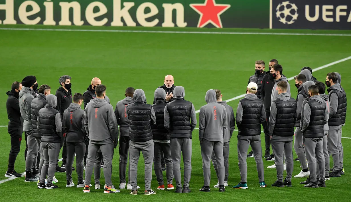 Pelatih AC Milan, Stefano Pioli (tengah) berbicara kepada para pemainnya di lapangan di Stadion Wanda Metropolitano di Madrid, Spanyol (23/11/2021). AC Milan akan bertanding melawan Atletico Madrid pada Grup B Liga Champions. (AFP/Oscar Del Pozo)