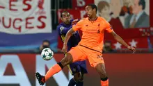 Pemain Liverpool, Joel Matip berebut bola dengan pemain Maribor, Marcos Tavares dalam lanjutan fase Grup E Liga Champions di Stadion Ljudski Maribor, Selasa (17/10). The Reds memetik kemenangan telak dengan skor meyakinkan 7-0. (AP/Darko Bandic)