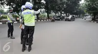 Sejumlah petugas mengawasi kendaraan yang melintas di kawasan Sudirman, Jakarta, Selasa (30/8). Pembatasan kendaraan bermotor berdasarkan pelat nomor ganjil dan genap di sejumlah jalan protokol di Jakarta resmi diberlakukan. (Liputan6.com/Yoppy Renato)