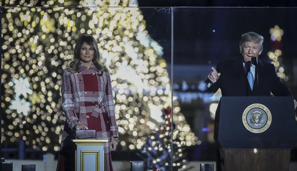 Presiden Donald Trump memimpin hitungan mundur, dan Ibu Negara Melania Trump menekan tombol lampu hias untuk menerangi Pohon Natal Nasional di taman sebelah selatan Gedung Putih, Kamis (5/12/2019). Pohon Natal Nasional tahun ini adalah cemara biru segar dari Colorado. (Drew Angerer/Getty Images/AFP)
