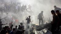 Warga Palestina memeriksa puing-puing bangunan yang hancur setelah serangan udara Israel di kota Khan Younis, Jalur Gaza selatan, Kamis, 26 Oktober 2023. (AP Photo/Mohammed Dahman)