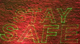 Piramida Besar Kheops memproyeksikan tulisan  "Stay home, stay safe" di tengah penyebaran pandemi corona Covid-19 di Giza, Mesir, Senin (30/3/2020). Piramida tersebut menampilkan pesan persatuan dan solidaritas bagi mereka yang memerangi virus corona di seluruh dunia. (Khaled DESOUKI/AFP)