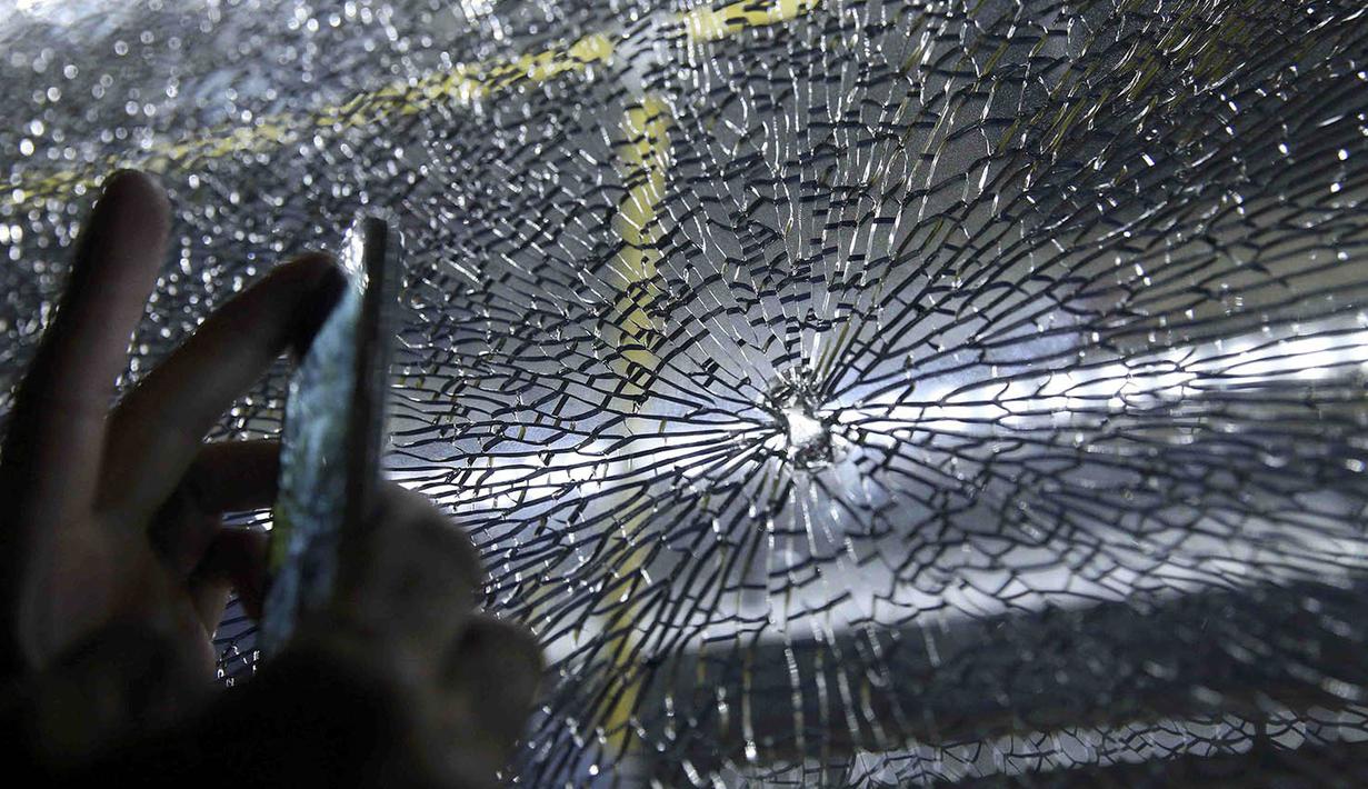 Kondisi kaca pecah pada sebuah bus yang mengangkut wartawan peliput Olimpiade 2016 Rio de Janeiro akibat terkena peluru nyasar. (Reuters/Shannon Stapleton)