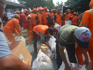 Petugas Penangganan Prasarana dan Saran Umum (PSSU) atau pasukan oranye mendapatkan sembako gratis di Jakarta, Jumat (3/8). Pembagian sembako gratis tersebut dalam rangka menyambut HUT ASABRI ke-47 tahun. (Merdeka.com/Imam Buhori)