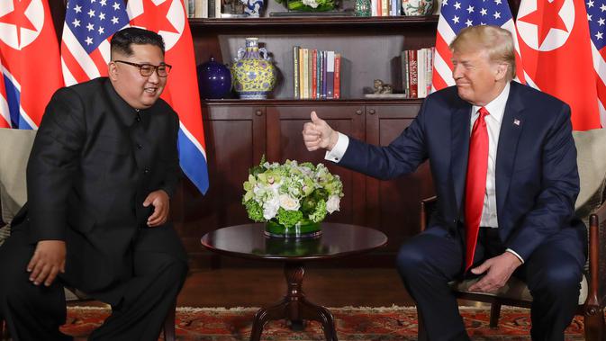 Presiden AS Donald Trump  memberikan jempolnya seusai berjabat tangan dengan Pemimpin Korea Utara, Kim Jong-un dalam pertemuan bersejarah di resor Capella, Pulau Sentosa, Selasa (12/6). Trump dan Kim saling melemparkan senyum. (AP/Evan Vucci)