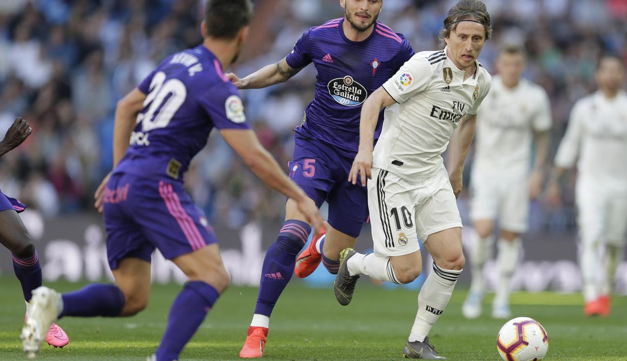 Gelandang Real Madrid, Luka Modric, berusaha melewati pemain Celta Vigo pada laga La Liga 2019 di Stadion Santiago Bernabeu, Sabtu (16/3). Real Madrid menang 2-0 atas Celta Vigo. (AP/Paul White)
