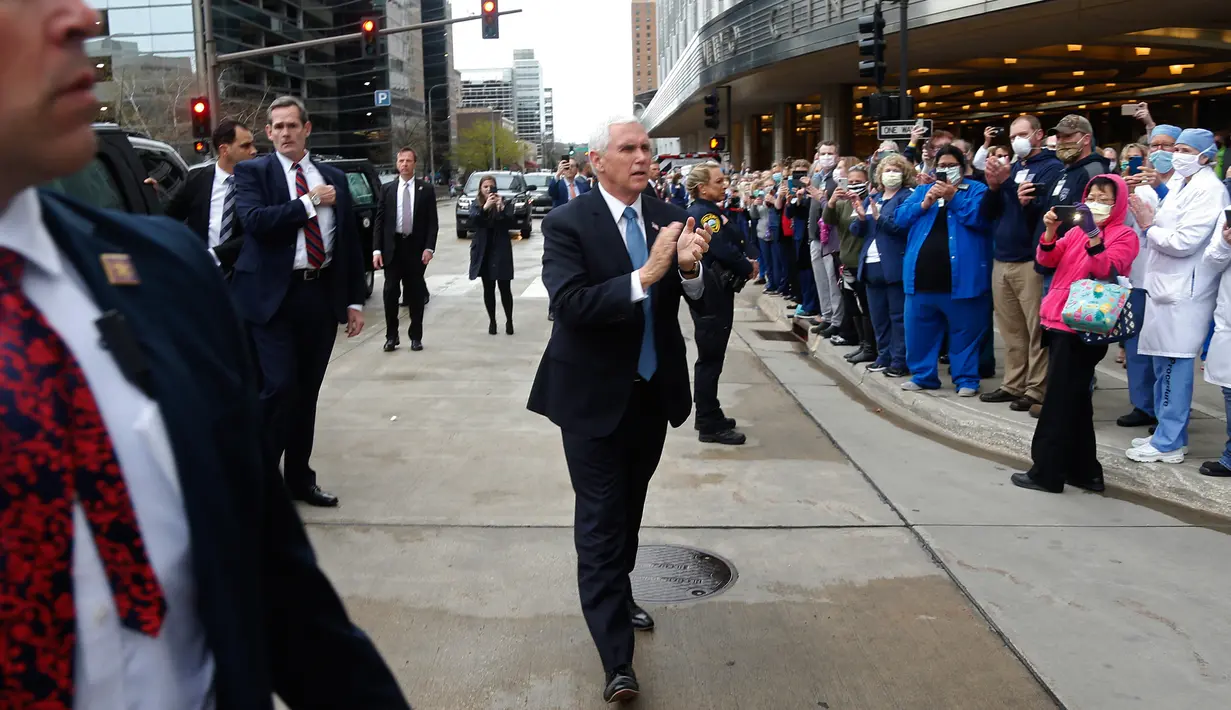 Wakil Presiden AS, Mike Pence memberikan tepuk tangan untuk karyawan Mayo Clinic yang antre menemui setelah kunjungannya di Rochester, Minnesota, Selasa (28/4/2020). Pence terlihat tanpa masker, meskipun ada aturan internal untuk semua orang yang masuk fasilitas itu wajib bermasker. (AP/Jim Mone)
