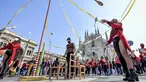 Seniman sirkus tampil di depan katedral gothic Duomo selama demonstrasi oleh pekerja sirkus di Milan, Italia utara (26/3/2021). Mereka menuntut lebih banyak dukungan dari pemerintah Italia karena kegiatan mereka ditutup sejak dimulainya wabah COVID-19. (Claudio Furlan/LaPresse via AP)
