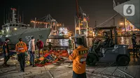 Petugas memindahkan serpihan Sriwijaya Air SJ 182 di Terminal JICT 2, Tanjung Priok, Jakarta, Kamis (21/1/2020).  Serpihan Sriwijaya Air SJ 182 dipindahkan dari Terminal JICT 2 ke kantor KNKT untuk dilakukan pemeriksaan dan identifikasi. (Liputan6.com/Faizal Fanani)