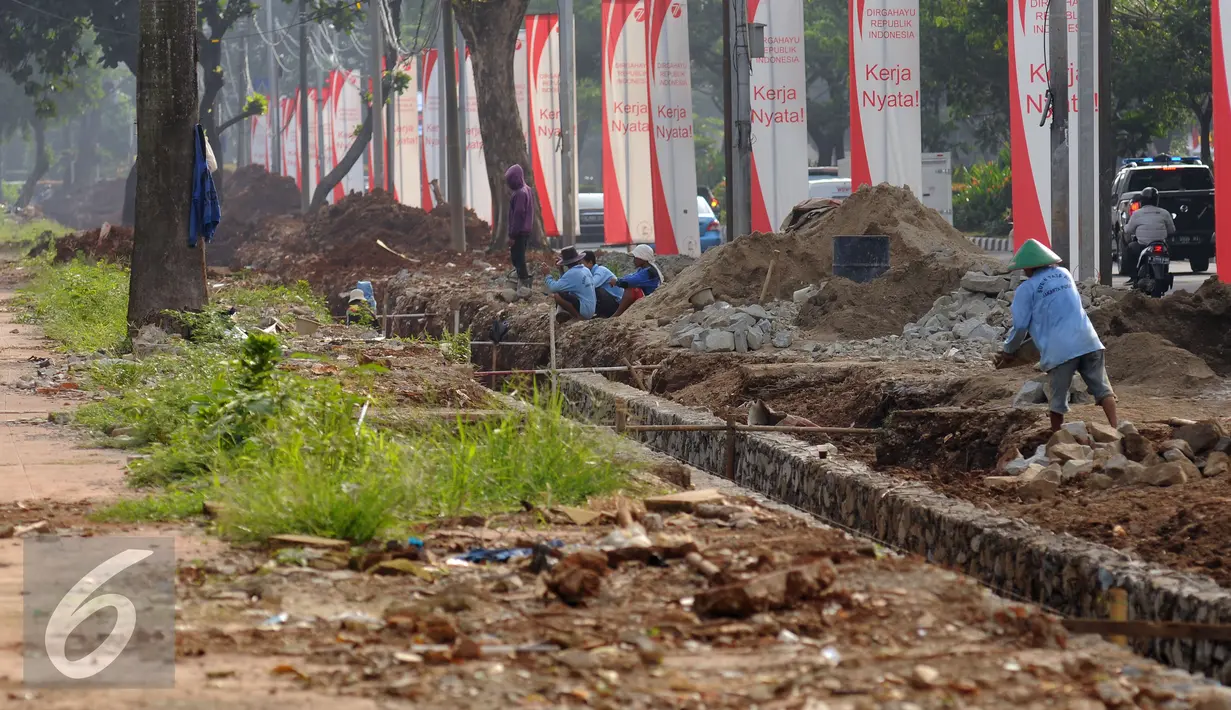 Pekerja menyelesaikan pembuatan saluran air di sekitar trotoar Jalan Gerbang Pemuda Senayan, Jakarta, Kamis (25/8). Pembenahan trotoar di Jalan Gerbang Pemuda dan Asia Afrika, ditargetkan selesai pada akhir 2017. (Liputan6.com/Helmi Fithriansyah)
